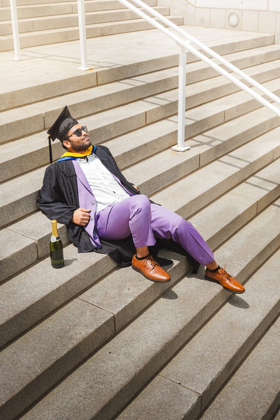 Graduation portrait on the steps with champagne